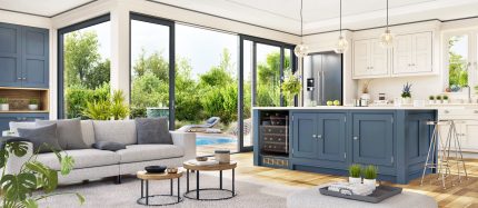 Modern Palm Desert kitchen and living room with large sliding glass windows opening to a backyard pool and garden. Modern Palm Desert kitchen and living room with large sliding glass windows opening to a backyard pool and garden.