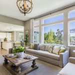 Sunlight shining into large living room with view of kitchen and backyard